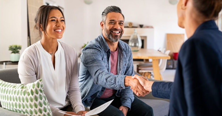 Woman & man seated shaking hands with a professional